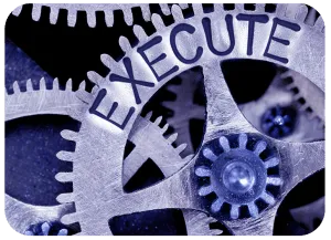 Interlocking metal gears with the word EXECUTE cut into them