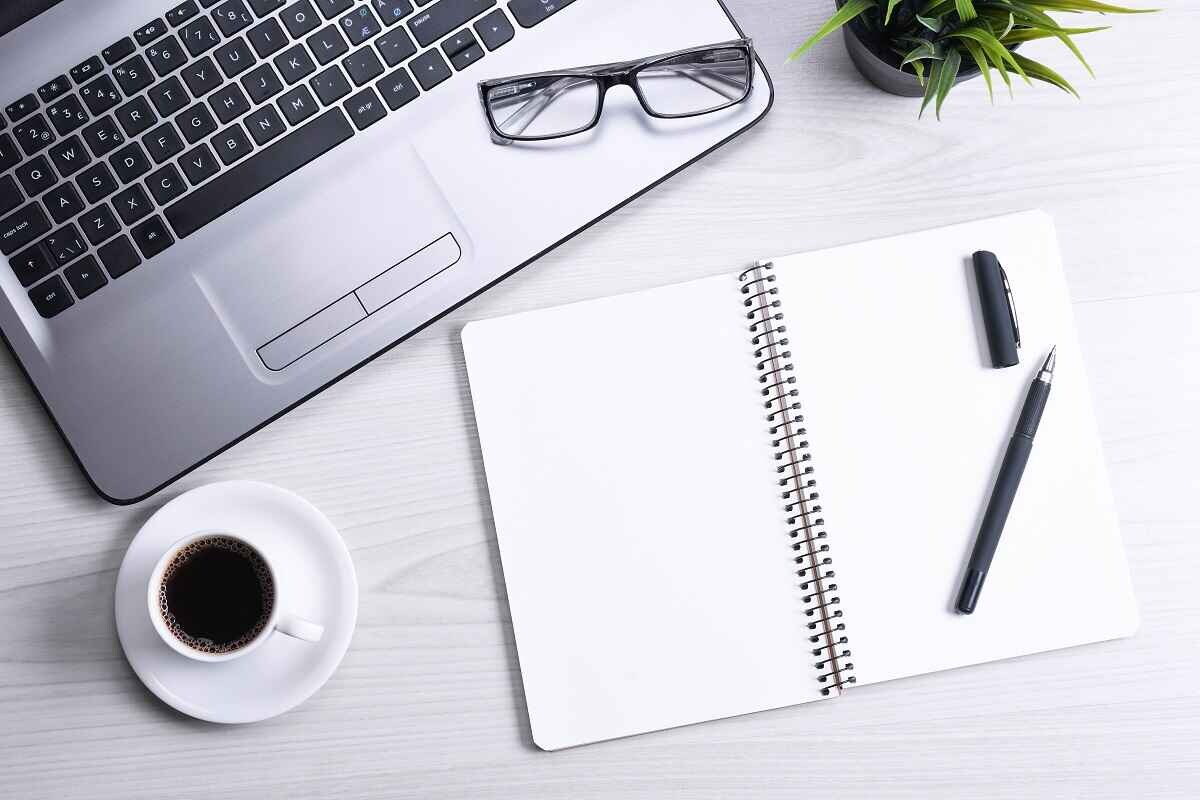 open notebook next to a laptop