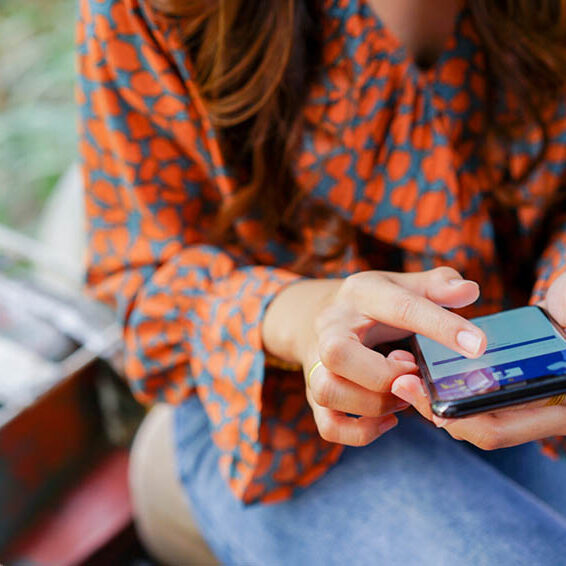 A Woman Holding a Smartphone and Browsing on Facebook