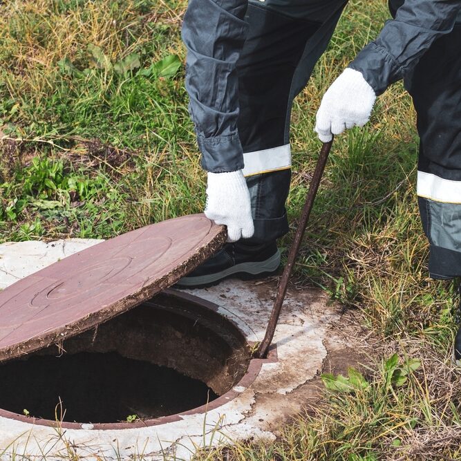 On,A,Septic,Sewer,Well,,A,Worker,Opens,The,Manhole